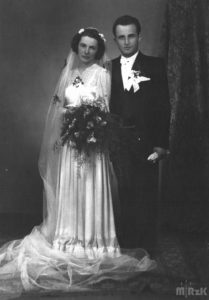 Fotografia biało czarna, na pierwszym planie stoi młoda para