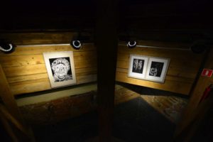 widok na oświetlone grafiki na drewnianej ścianie