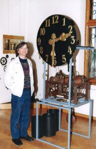 Władysław Michna stoi przy tarczy zegara