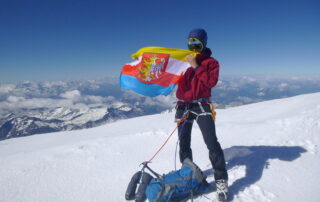 mężczyzna na szczycie góry trzymający flagę Krosna