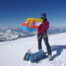 mężczyzna na szczycie góry trzymający flagę Krosna